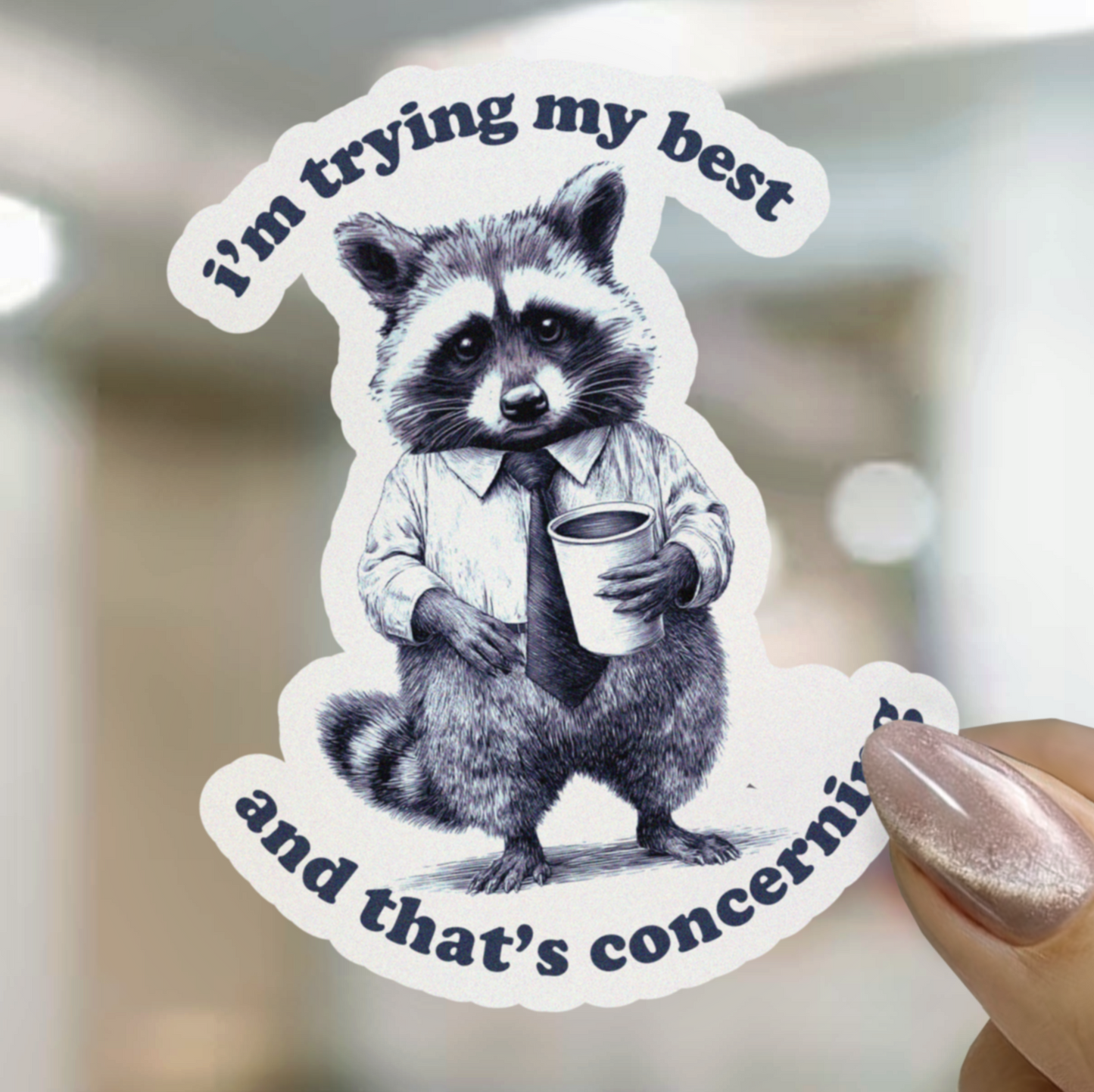 Sticker of a raccoon holding a cup with text 'I'm trying my best and that's concerning' held by a hand.