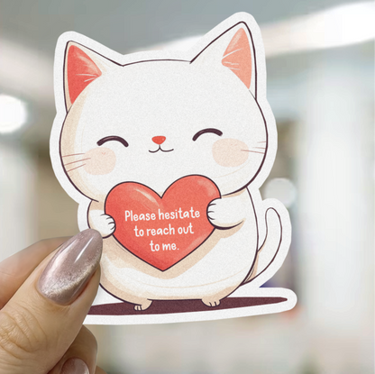 Sticker of a cat holding a heart with text, held by a hand.