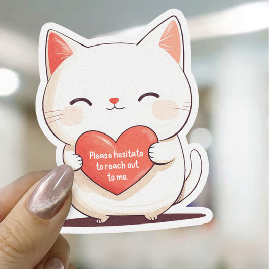 Sticker of a cat holding a heart with text, held by a hand.